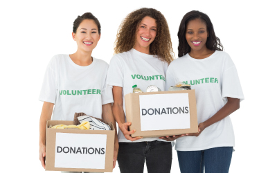 three volunteers holding donation boxes